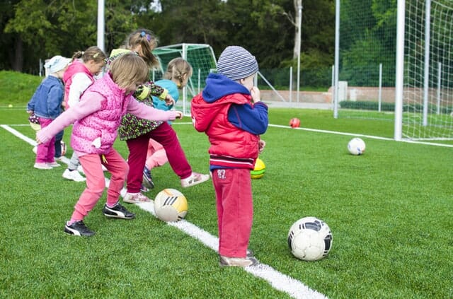 budget beating ideas | kids playing football on a large AstroTurf field