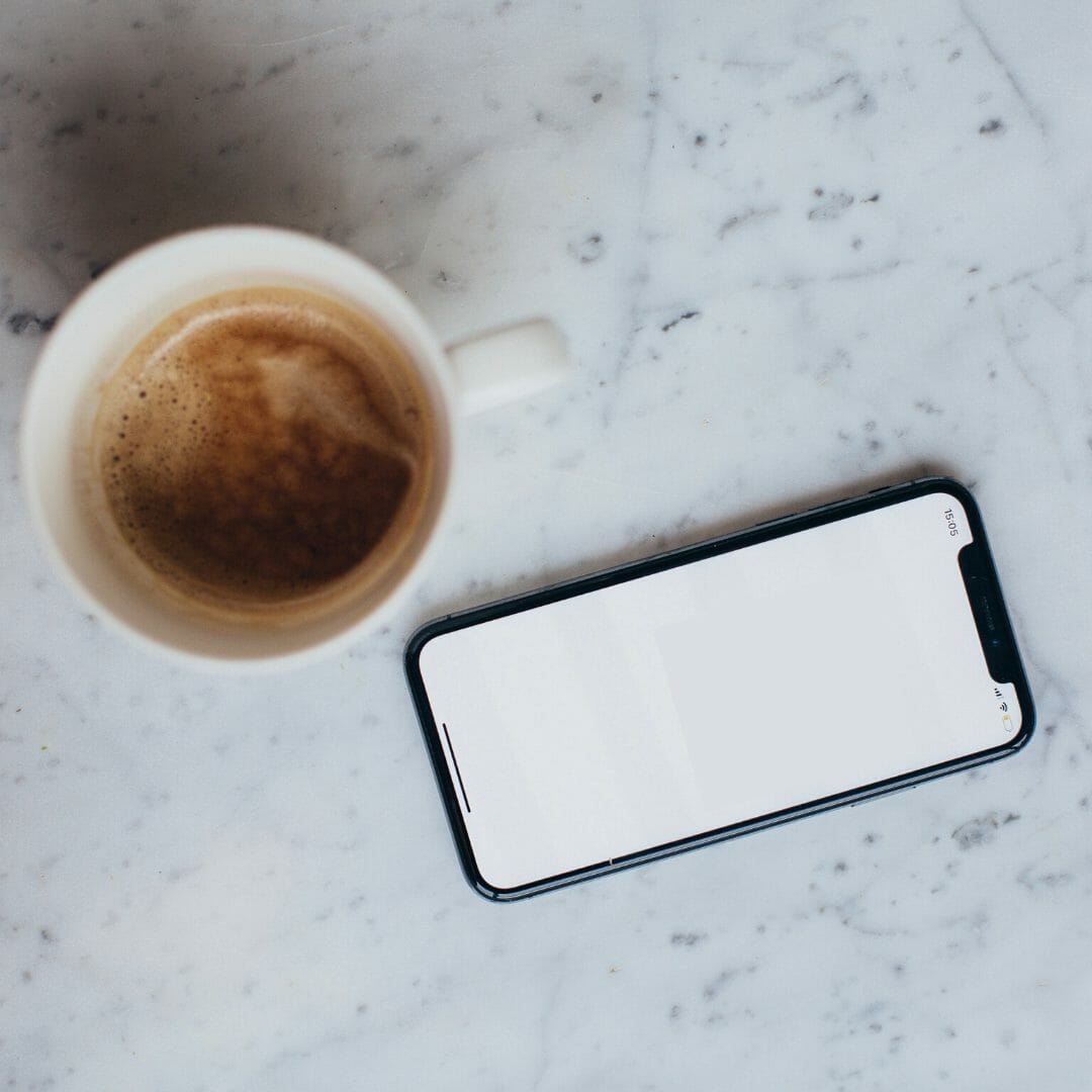 latest iPhone 11 lay on a table next to a coffee